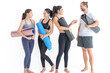 © ultramansk - Group of happy sporty women and guy wearing body stylish sportswear holding personal carpets leaned on a white background. waiting for yoga class or body weight class. healthy lifestyle and wellness