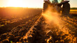 Tractor tilling soil at sunset, farming and agriculture.
