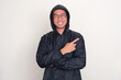 © KrishnaTedjo - A man wearing raincoat pointing to the left side with happy expression
