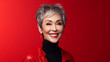 Elegant, smiling, elderly, chic Asian woman with gray hair and perfect skin on a red background banner.