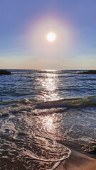 Wall Mural - colorful sunset with large sun under the sea waves.