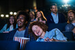 © Marko Geber - Young couple sharing popcorn during a movie in cinema