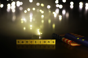 Poster - Word Sanctions made of wooden block letters with dramatic lighting and smoke