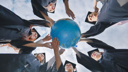 Wall Mural - Graduating students twirl a geographic globe of the world in their hands.