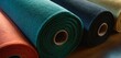  a close up of a row of different colored rolls of fabric on a wooden surface with one rolled up and the other rolled up in a row of different colors.