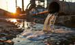 Rusty pipe discharging wastewater into a stream at sunset.