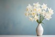 Bouquet of daffodils in a white vase on a blue background. Place for text