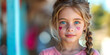 Ein kleines Mädchen in einem rosafarbenen Oberteil mit Herzen auf der Wange
