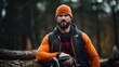 A picture of a lumberjack who is dressed in protective gear and holding a chainsaw
