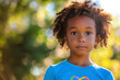 Young afro american girl with an infinity rainbow symbol on her shirt symbolises hope and support for autism awareness