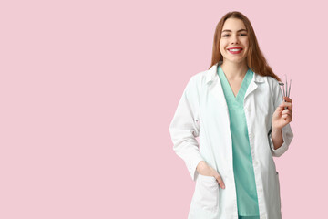 Wall Mural - Female dentist with dental tools on pink background. World Dentist Day