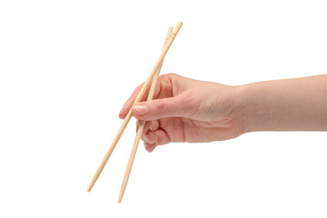 Wall Mural - Female hand holding wooden sushi chopsticks isolated on white background.