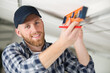 young repairman holding a spirit level smiling to the camera