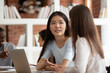 © fizkes - Millennial Asian female talk brainstorming with teammate work on shared school project together, multiracial girl students speak chat cooperating studying discussing or sharing ideas at lesson