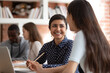 © fizkes - Happy indian female student talk discuss sharing ideas brainstorming at lesson with teammate, smiling ethnic girl cooperating work on school project using laptop studying in classroom together