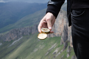 Wall Mural - compass in hand of man on mountain top. compass on top of mountain.