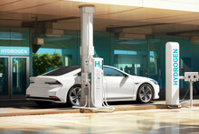 A white sedan car refueling at a hydrogen fuel station on a sunny day. Emission free eco friendly transport