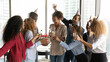 © fizkes - Best wishes. Multiethnic company staff congratulate black woman coworker with birthday promotion career growth. Happy friendly bank department workforce present gift to happy colleague on office party