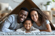 Happy multiethnic family with child holding cardboard roof