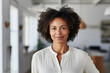 Afro-American middle aged business woman, freelance professional, entrepreneur, interior designer portrait. Black woman standing inside home office, new house, inside modern white room