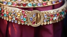 Closeup Of A Statement Belt, Featuring A Large Gold Buckle And Studded With Colorful Rhinestones.