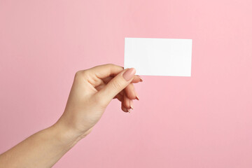 Sticker - Woman holding blank business card on pink background, closeup. Mockup for design