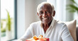 © Alena Yakusheva - natural portrait of a senior elderly black skinned man with a gift box, blurred home interior background