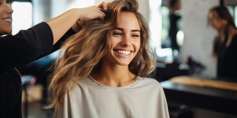 Female hairdresser is fixing hair of smiling woman