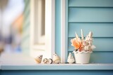Fototapeta  - closeup of pastel blue cottage with seashells on window sill