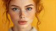 Headshot of a beautiful, sensual female fashion model with loosely coifed red hair. Full lips and an immaculate complexion. Skin care and cosmetics.