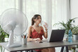 © StockPhotoPro - Woman cooling herself at home