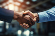 Close-up of a firm handshake between two professionals in a corporate environment, symbolizing partnership and agreement in factory garage workshop.