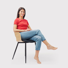 Wall Mural - Portrait of a young woman sitting on a chair