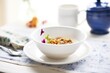white bowl with sachet and granola breakfast