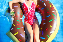 Young Woman On Inflatable Mattress In The Swimming Pool