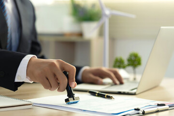 Businessman Hand Stamping With Approved Stamp On Document At Desk. validates and manages business documents and agreements, and approves business cooperation to comply with environmental laws. ESG