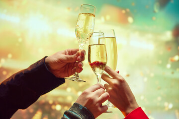 Wall Mural - Hands clinking champagne glasses, flutes over light bokeh background. Cheerfully New Years celebration, meeting. Concept of holidays, friendship, fun, joy, leisure, events