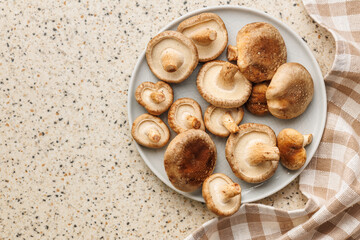 Wall Mural - Fresh shiitake mushrooms on plate on kitchen table. Top view.