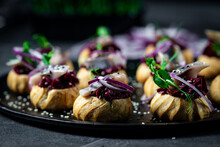 Profiteroles With Herring, Cottage Cheese And Red Onion On A Dark Background