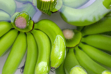 Wall Mural - Raw green bananas soaking the bananas in water. Cleaning fruits