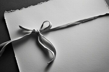 Poster - A piece of paper with a ribbon tied to it. Perfect for gift wrapping or adding a decorative touch to any project