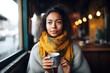 woman sipping latte, scarf and cozy sweater visible
