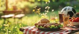 Picnic on a meadow with bratwurst on flaming grill and a soccer ball. Copy space image. Place for adding text
