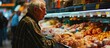 Mature man buyer of meat department of grocery store looking at hen in refrigerator window Elderly male customer points with finger and orders whole chicken fresh poultry. Copy space image