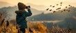 child observes birds with binoculars in the wild birdwatching in childhood. Copy space image. Place for adding text