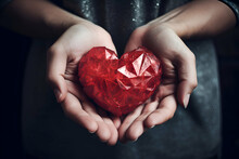 Red Heart In The Hands Of A Girl On A Dark Background.