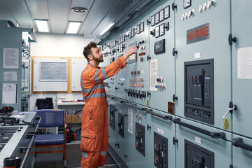 Wall Mural - Young engineer working in engine control room on electrical distribution system.