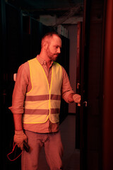 Wall Mural - joyous devoted technician in safety gloves and vest working hard in information center, banner