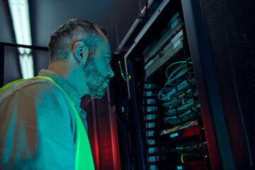 Wall Mural - handsome dedicated technician with beard in safety vest working hard in information center