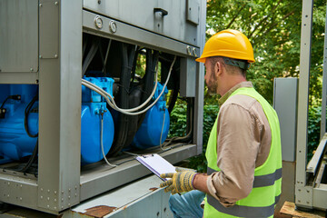 Wall Mural - focused professional in safety clothes and helmet checking outside part of data center, banner